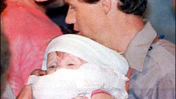 A rescue worker carries 18-month-old Jessica McClure in this Oct.16,1987 file photo, shortly after she was rescued from an abandoned water well at Midland ... - image620405x