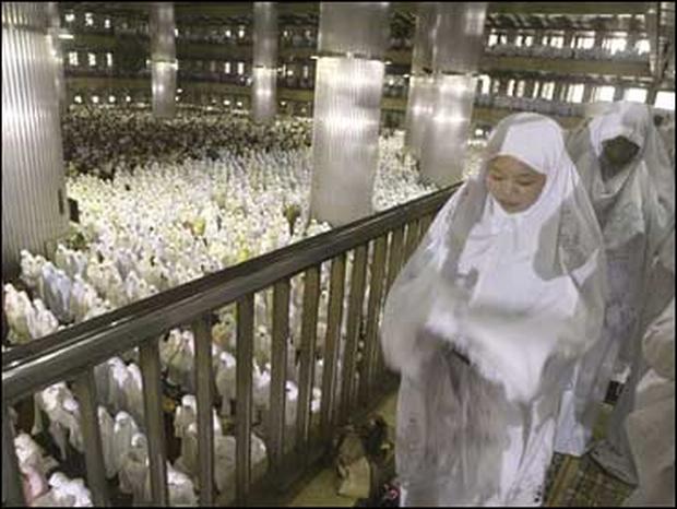 Muslim women perform a morning prayer marking the start of the Islamic feast of Eid al-Fitr at Istiqlal mosque in Jakarta