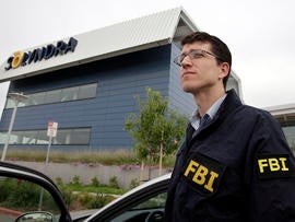 An FBI agent stands guard outside of Solyndra headquarters in Fremont, Calif., Sept. 8, 2011, while the bureau was executing search warrants at the headquarters of the solar firm that received a $535 million loan from the federal government.