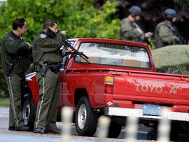 Police search a neighborhood in Cupertino, Calif., Oct. 5, 2011, looking for a shooting suspect. Authorities say a disgruntled employee opened fire at the Permanente Quarry, killing two people and wounding at least six others during a morning meeting. Later, a woman was shot in an attempted carjacking by a man matching the gunman's description, authorities said.