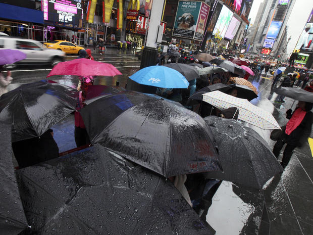 Umbrellas shelter people waiting to buy Broadway theater tickets in New York's Times Square, Sunday as leading edge of nor'easter hits on April 22, 2012