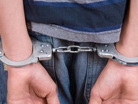 A kid in handcuffs.
