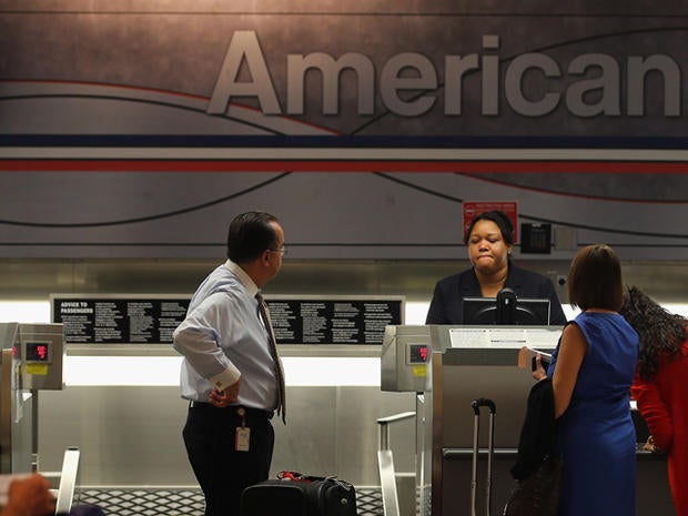 An American Airlines employee helps travelers at the ticket counter in the Miami International Airport on September 18, 2012 in Miami, Florida. Nearly 10 months after the airline filed for bankruptcy protection, the company announced that it will be sending out layoff warning notices to more than 11,000 employees although it expects job losses to be less than that.