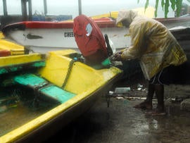 Fisherman Hubert Dowie works to secure his boat before the arrival of Hurricane Sandy in Port Royal, Jamaica, Oct. 24, 2012.