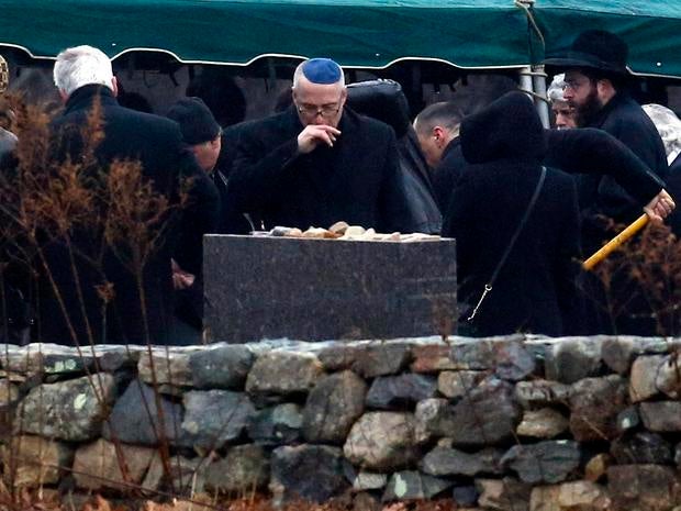 A man, center, reacts while others shovel dirt onto the grave of Noah Pozner, a six-year-old killed in the Sandy Hook Elementary School shooting, was laid to rest at B'nai Israel Cemetery, Monday, Dec. 17, 2012, in Monroe, Conn. Authorities say gunman Adam Lanza killed his mother at their home on Friday and then opened fire inside the Sandy Hook Elementary School in Newtown, killing 26 people, including 20 children, before taking his own life.