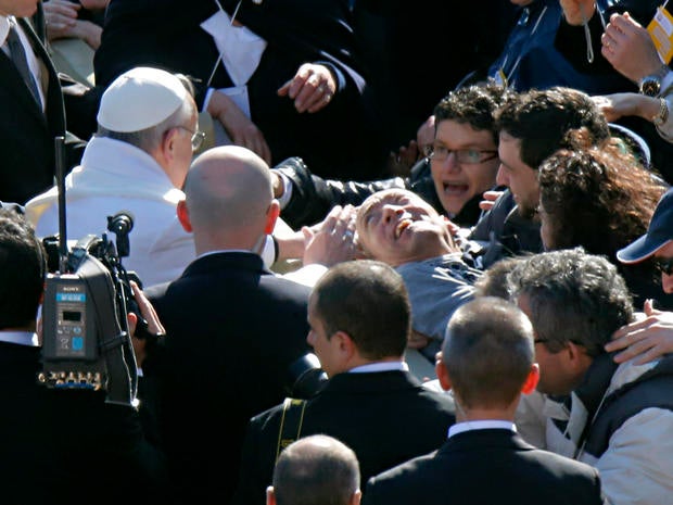 Pope Francis blesses a disabled man prior to his inaugural Mass