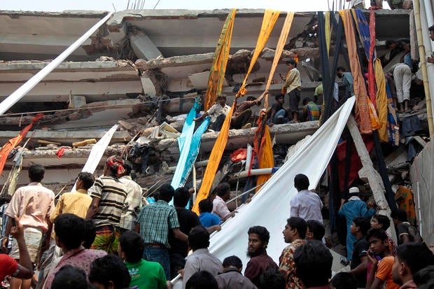 Rescue workers use long swathes of cloth to bring down survivors and bodies after an eight-story building collapsed