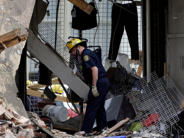 firefighter walks through the aftermath of a building collapse, Thursday, June 6, 2013, in Philadelphia. On Wednesday, the building under demolition collapsed onto a neighboring thrift store, killing six people and injuring 13.