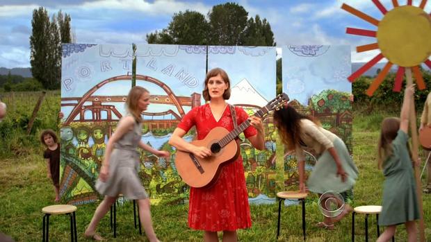 A woman plays a guitar in this quirky video about Oregon's new healthcare marketplace, Cover Oregon.