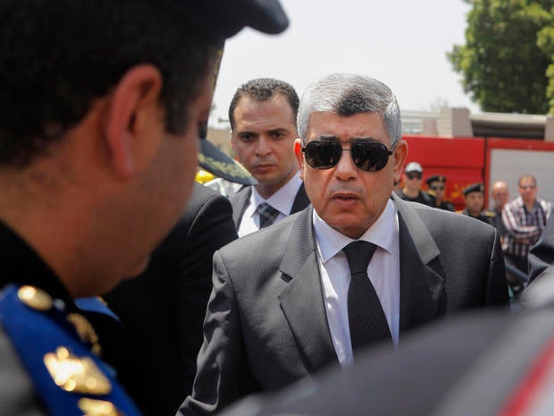 Egyptian Interior Minister Mohammed Ibrahim, right, gives his condolences to a policeman during a military funeral in Cairo, Egypt. Aug. 15, 2013.