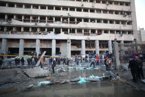 Egyptian police officers and firefighters gather at the Egyptian police headquarters after a blast in downtown Cairo
