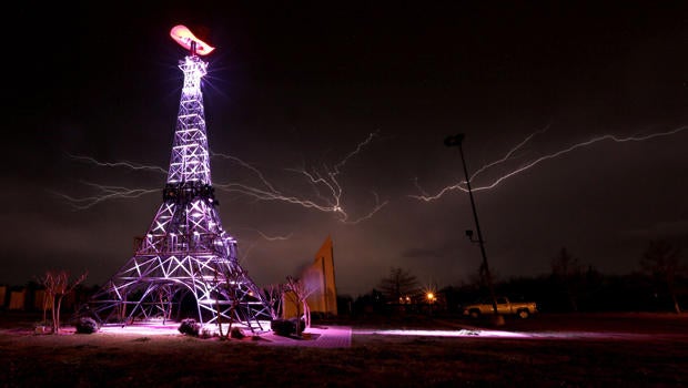 Lightning rips through the night sky April 3, 2014, behind a replica Eiffel Tower in Paris, Texas, as a severe thunderstorm moved through the southern part of Lamar County, bringing high winds, rain and hail.