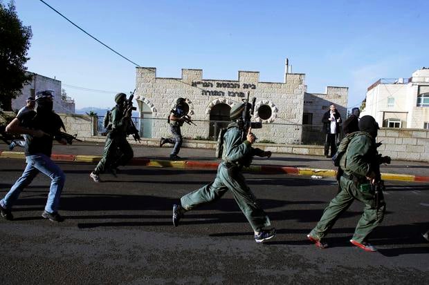 Israeli security personnel run next to a synagogue, where an attack took place in west Jerusalem