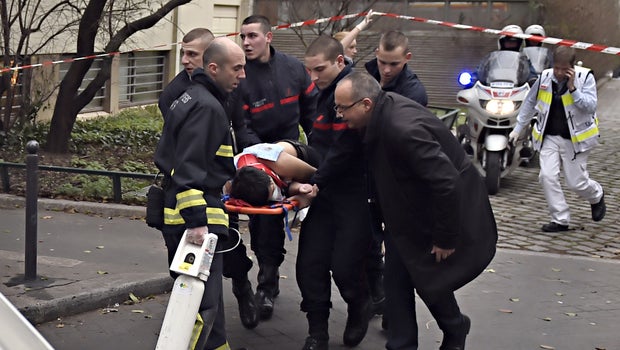 A victim is evacuated on a stretcher, Jan. 7, 2015, after armed gunmen stormed the offices of the French satirical newspaper Charlie Hebdo