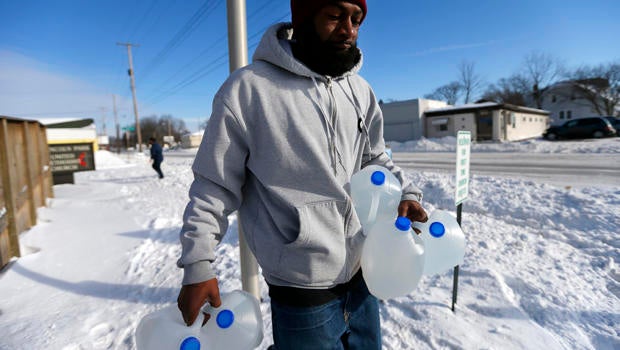 Lemott Thomas carries free water being distributed at the Lincoln Park United Methodist Church in Flint, Mich., Feb. 3, 2015.