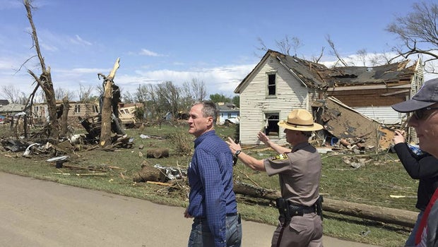 South Dakota Governor Dennis Daugaard (L) surveys damage from a tornado that touched down in Delmont, South Dakota in this handout photo