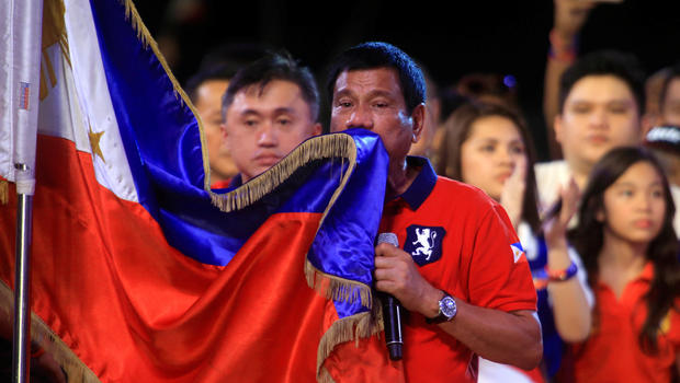 Philippine presidential candidate and Davao city mayor Rodrigo Duterte kisses the Philippine flag during a political campaign rally before the national elections at Rizal park in Manila, Philippines