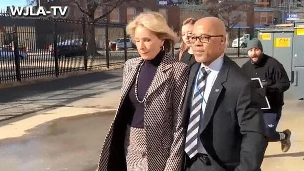 Education Secretary Betsy DeVos walks with a bodyguard to a SUV after protesters blocked her from entering Jefferson Middle School in Washington, D.C., on Feb. 10, 2017.