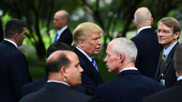 El entonces candidato presidencial republicano Donald Trump está rodeado por los miembros del Servicio Secreto cuando visita la tumba del ex presidente Gerald Ford en Grand Rapids, Michigan, el 30 de septiembre de 2016. 