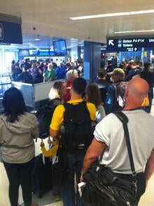 Travelers at Chicago O'Hare International Airport gather after a fire at a FAA facility led to a ground stop of all flights in and out of Chicago's airports.