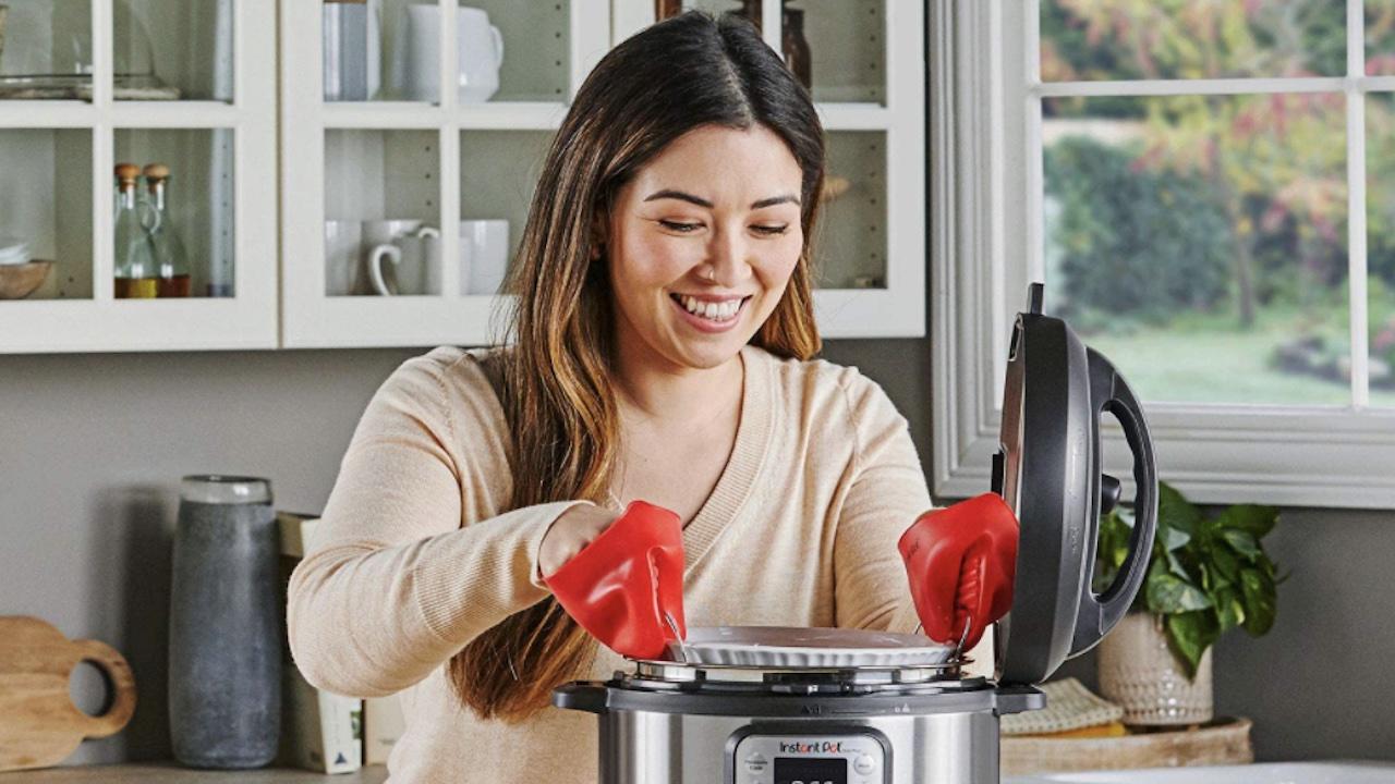 A woman removes food from an Instant Pot 