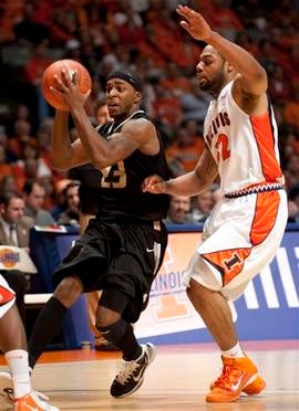 Oakland guard Reggie Hamilton (23) is defended by Illinois guard Demetri McCamey (32).