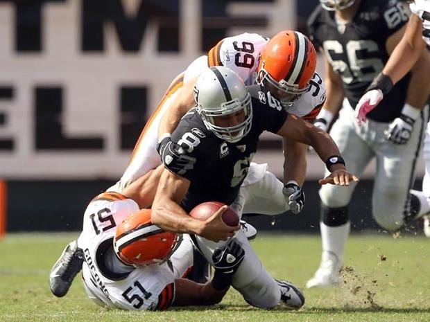 OAKLAND, CA - OCTOBER 16: Jason Campbell #8 of the Oakland Raiders is hit by Chris Gocong #51 and Scott Fujita #99 of the Cleveland Browns at O.co Coliseum on October 16, 2011 in Oakland, California. Campbell was injured on the play and had to be helped from the field. (Photo by Ezra Shaw/Getty Images)