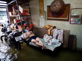 A Thai resident watches television in his flooded home in Chinatown near the overflowing Chao Phraya river Oct. 26, 2011, in Bangkok. Floodwaters are threatening to disrupt Thailand's tourism industry as the country experiences its worst flooding in 50 years.