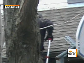 Image from undercover video provided by the National Insurance Crime Bureau shows a contractor claiming to inspect a house who's really inflicting damage he would say was caused by hail, to try to collect insurance money for fixing it.