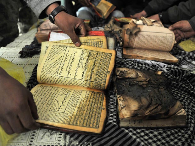 Afghan demonstrators show copies of Koran books allegedly set alight by U.S. soldiers.