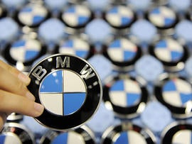A worker holds up a logo of German carmaker BMW at the company's plant in the southern German city of Dingolfing on October 12, 2009. BMW constructs their 5, 6 and 7 series cars at the plant in Dingolfing. AFP PHOTO DDP / OLIVER LANG GERMANY OUT (Photo credit should read OLIVER LANG/AFP/Getty Images)