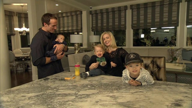 In the family room, Drew and Brittany are greeted by their three boys.