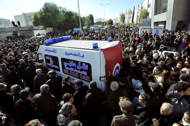 People surround an ambulance transporting the body of Chokri Belaid in Tunis