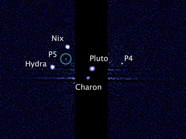 This image, taken by NASA's Hubble Space Telescope, shows five moons orbiting the distant, icy dwarf planet Pluto. The green circle marks the newly discovered moon, designated P5, as photographed by Hubble's Wide Field Camera 3 on July 7, 2012.