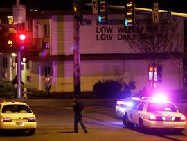 A Washington State Patrol trooper directs a driver away from a street blocked off several blocks from the scene of an overnight shooting that police said left five people dead, Monday, April 22, 2013, at an apartment complex in Federal Way, Wash.