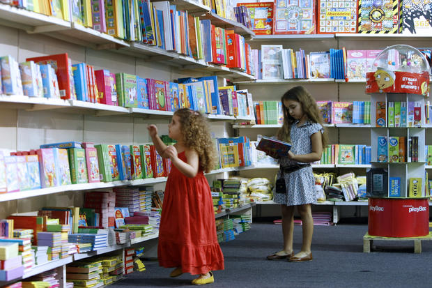 Two girls pick books from the children's 