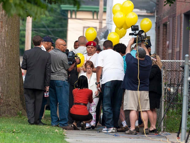 Michelle Knight, center, talks with reporters Aug. 7, 2013, outside the home of Ariel Castro in Cleveland.