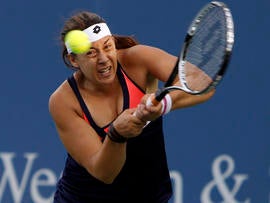 Marion Bartoli, from France, returns against Simona Halep, from Romania, during a match at the Western & Southern Open tennis tournament Aug. 14, 2013, in Mason, Ohio.