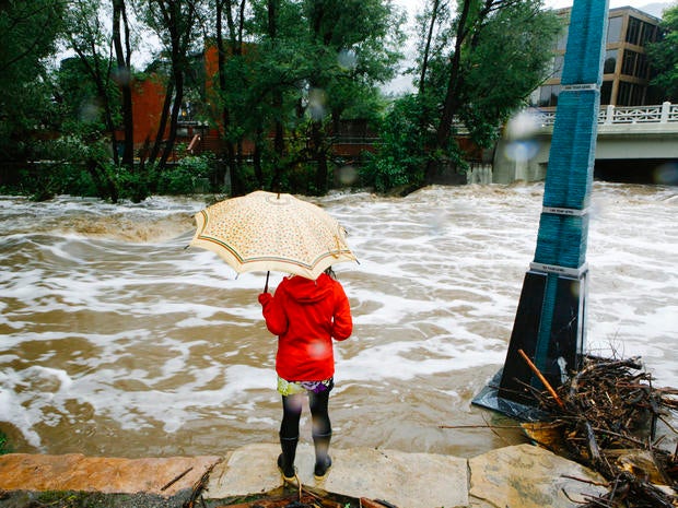 A woman looks at Boulder Creek, which flooded early Sept. 12, 2013, after three days of heavy rainfall in Boulder, Colo.