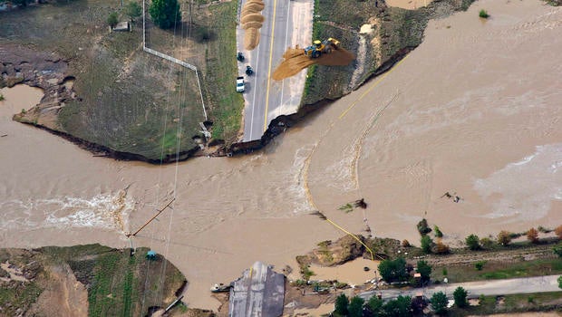 A road crew works on a stretch of highway washed out by flooding along the South Platte River in Weld County, Colorado near Greeley, Saturday, Sept. 14, 2013. Hundreds of roads in the area have been damaged or destroyed by the floodwaters that have affected parts of a 4,500-square-mile area.