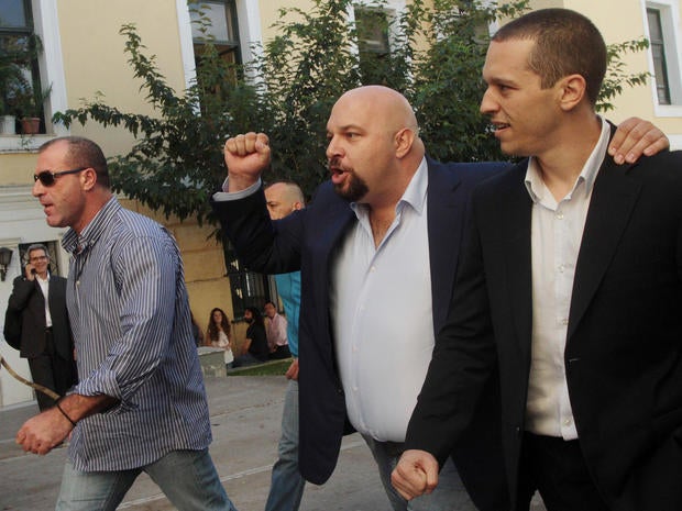 Lawmakers of the extreme far-right Golden Dawn party, Ilias Kasidiaris, right, Ilias Panayiotaros, center, and Nikos Michos, left, leave a court after after judicial authorities' decision to release them