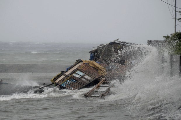 A house is engulfed by the storm surge from Typhoon Haiyan, as it hits Legazpi city