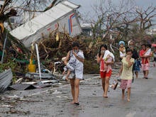 Residents shield their noses from the smell of dead bodies in Tacloban city