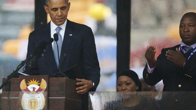 President Obama looks down as he stands next to a sign-language interpreter as he makes his speech at the memorial service for former South African President Nelson Mandela at FNB Stadium in Soweto near Johannesburg Dec. 10, 2013. 