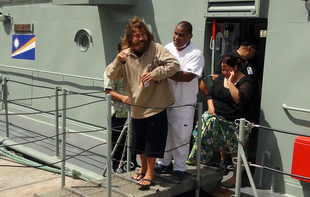 A castaway from Mexico who identified himself as Jose Salvador Alvarenga steps off the "Lomor" Sea Patrol vessel in Majuro, Marshall Islands, with the help of a nurse