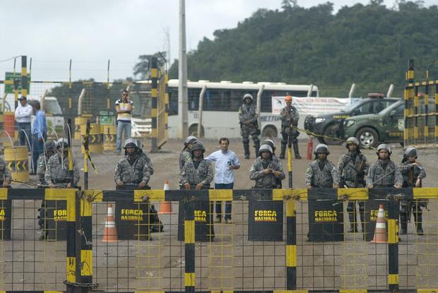 Police officers stand guard during a demonstration against Norte Energia - the company responsible for the construction of Belo Monte hydroelectric power plant - demanding compensation for the loss of income from the flooding of the Xingu river near Altamira, in the northern state of Para, Brazil