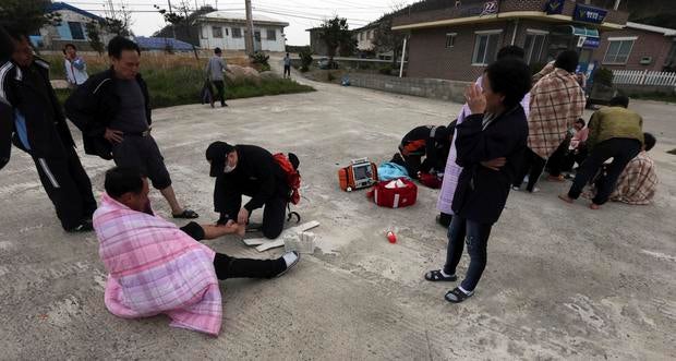 An injured passenger rescued by South Korean maritime policemen from the sinking ship Sewol in the sea off Jindo is treated at a port in Seogeochado April 16, 2014.
