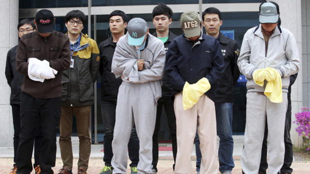 Crew members of the sunken Sewol ferry stand outside a court in Mokpo, South Korea, after investigators sought warrants of their arrest at the court April 26, 2014. 