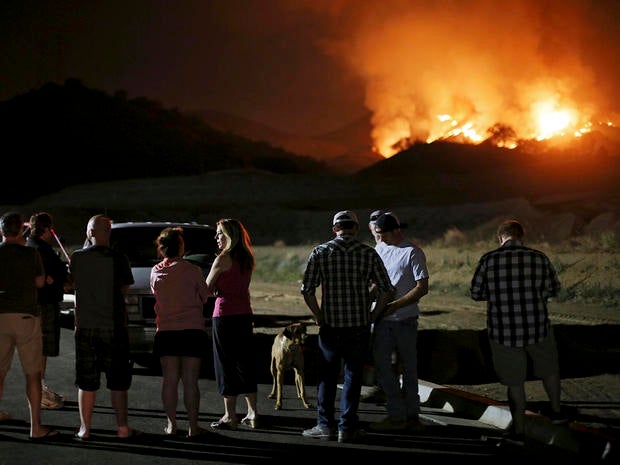 Residents watch a fast-moving wildfire approach in San Marcos, California, May 14, 2014.