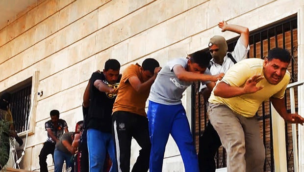 This image posted on a militant website June 14, 2014, which has been verified appears to show militants from the al-Qaeda-inspired Islamic State of Iraq and Syria (ISIS) leading away captured Iraqi soldiers in plain clothes after taking over a base in Ti